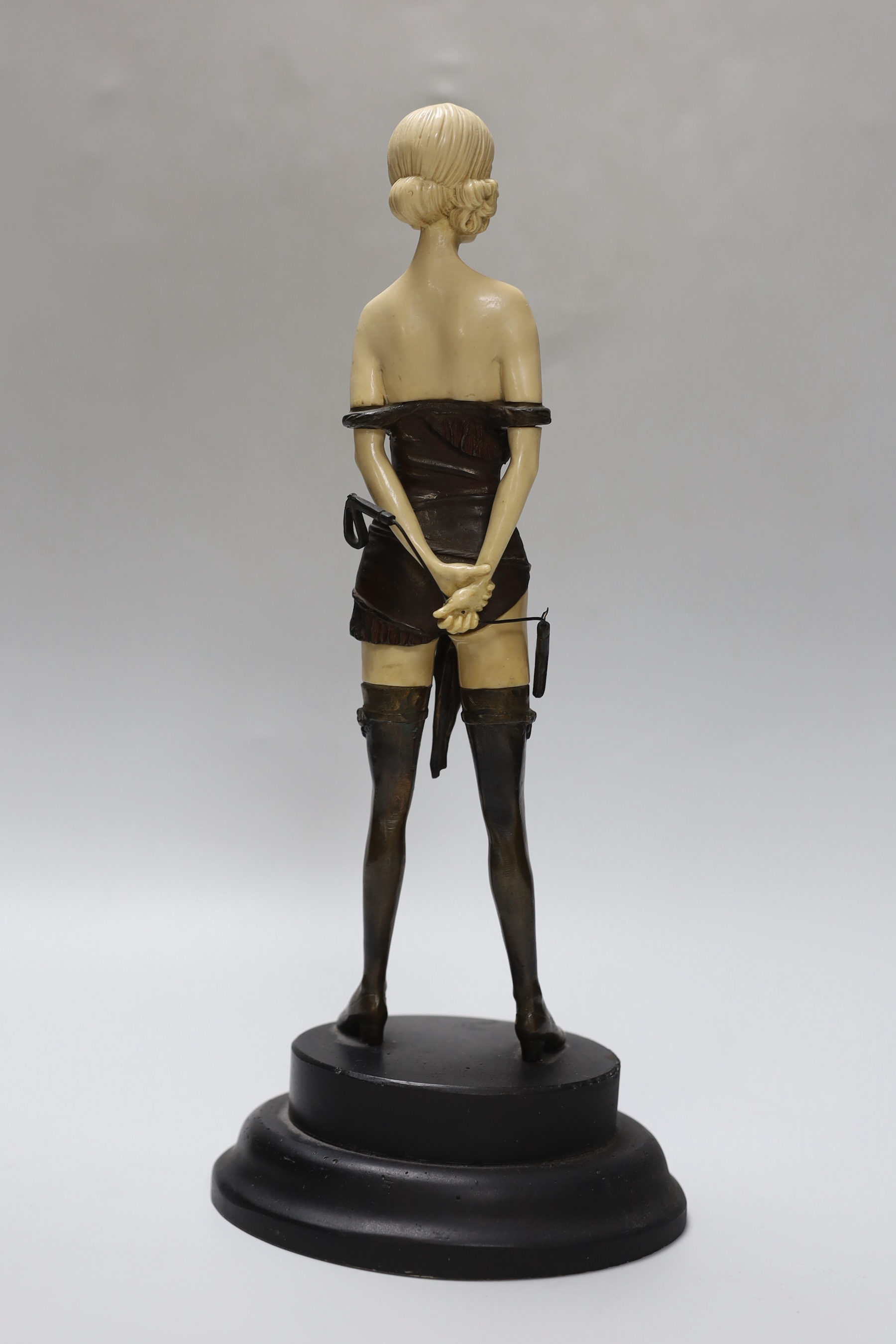 An Art Deco style bronze and resin standing figure; The Riding Crop, after Bruno Zach, 32cm